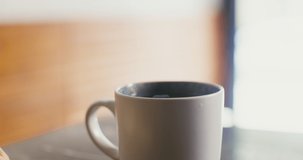 Large white mug with steaming hot coffee, steam visible. Close-up. No people on video