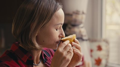 Young woman testing fresh keto bread. Close-up slow motion shot. Woman bite homemade bread