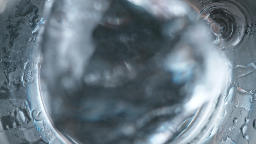 Super slow motion of falling ice cube into Vodka drink. Overhead shot. Filmed on high speed cinema camera, 1000fps. Royalty-Free Stock Footage #1083609442