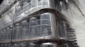 New aluminum beer cans stacked on pallet rack in warehouse in brewery. Unused aluminium can stock for cold beverages