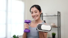 Training holding dumbbell and virtual glasses. Young asian sport woman wearing sportswear workout with virtual simulated world. Into the metaverse future digital cyber universe. Future technology