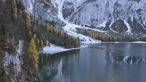 Famous lake Braies in autumn Dolomites mountains. Forest with larches and pines reflected in clear water of Lago di Braies, Dolomite Alps, Italy. Seekofel mountain on background. UHD 4k video