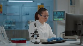 Lab worker using magnifying glass on microscope to work on science experiment. Woman chemist analyzing dna substance with microscopic lens on optical tool in laboratory. Biology researcher - Powered by Shutterstock - Get 15% off with code: PIKWIZARD15