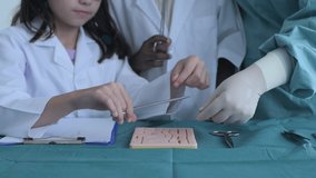 Education concept of 4k Resolution. Medical school students practicing suturing wounds in classroom. internship doctor. training simulation. - Powered by Shutterstock - Get 15% off with code: PIKWIZARD15