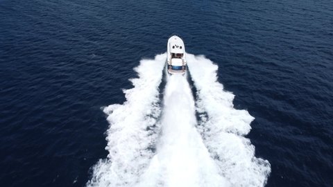 Overhead view of motorboating at high speed creating huge wake on water surface. Aerial