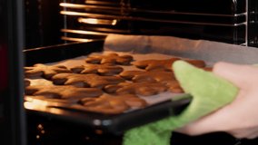 Girl's hands take out baked Christmas cookies from the oven - Powered by Shutterstock - Get 15% off with code: PIKWIZARD15