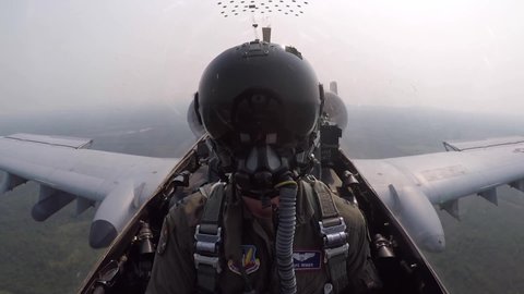 CIRCA 2020s - Cockpit footage of a Fairchild Republic A-10 Thunderbolt II Warthog close support fighter jet pilot flying over rural terrain.