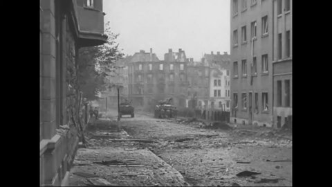 CIRCA 1944 - American soldiers drive M-4 tanks down a war-torn street in Aachen, Germany.