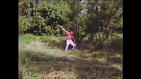 CIRCA 1977 - In this Blaxploitation movie, a man fights off an attacker while his friends cheer him on.