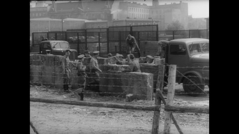 CIRCA 1966 - A prefabricated wall is put up in place of the barbed wire constituting the Berlin Wall.