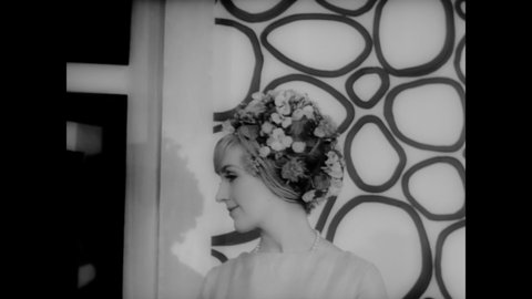 CIRCA 1965 - Women model hats in an outdoor spring fashion show.
