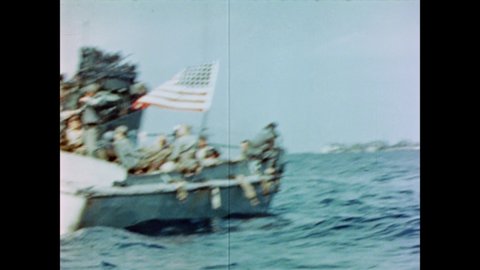 CIRCA 1945 - US Marines carry American flags aboard landing crafts headed towards Iwo Jima.