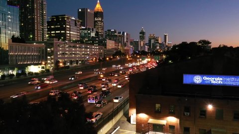 ATLANTA, GEORGIA - CIRCA 2020s - Beautiful rising aerial shot of Atlanta, Georgia freeway and downtown skyline at dusk, sunset or night.