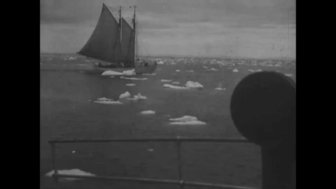 CIRCA 1925 - Ships on Donald MacMillan's scientific expedition navigate past ice floes in Greenland.