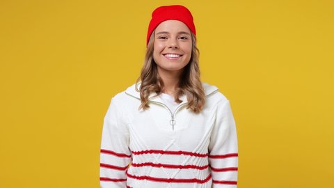 Beautiful cheery happy blithesome young girl teen student wears striped white shirt hat looking camera smiling isolated on plain yellow background studio portrait. People emotions lifestyle concept