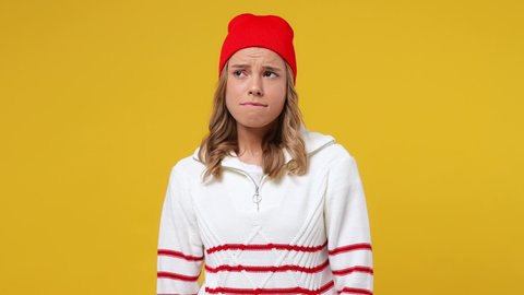 Beautiful boring dull tedious uninspired sad young girl teen student wears striped white shirt hat looking around take mobile cell phone use smiling isolated on plain yellow background studio portrait