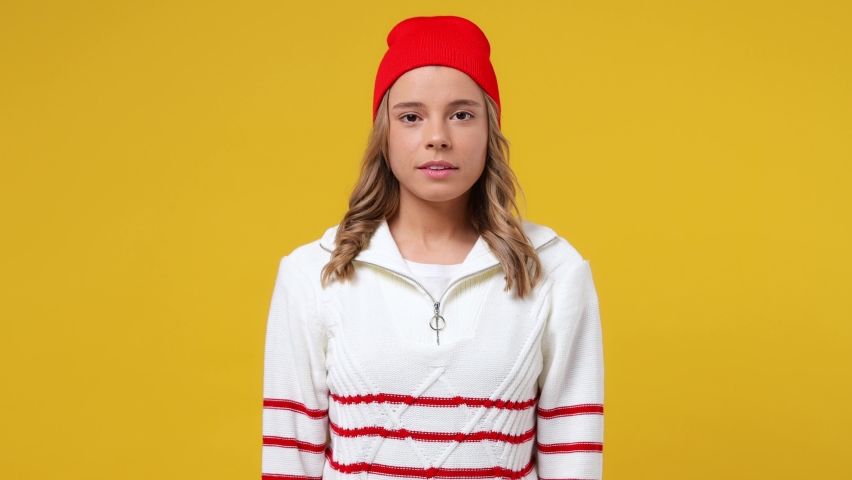 Beautiful confused shy shamed young girl teen student wears striped white shirt hat look camera spreading hands say oops ouch oh omg i am so sorry isolated on plain yellow background studio portrait Royalty-Free Stock Footage #1083639475