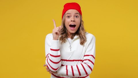 Excited insighted young girl teen student wears striped white shirt hat looks around thinks scratches at temple comes up with ideas raised finger isolated on plain yellow background studio portrait