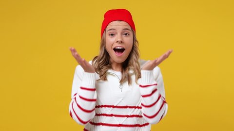 Joyful jubilant surprised shocked young girl teen student wears striped white shirt hat say wow omg what spreading hands put arms on face screech isolated on plain yellow background studio portrait