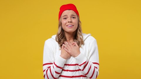 Smiling good kind happy young girl teen student wears striped white shirt hat ask who me oh it so sweet put hands on chest isolated on plain yellow background studio portrait. People emotions concept
