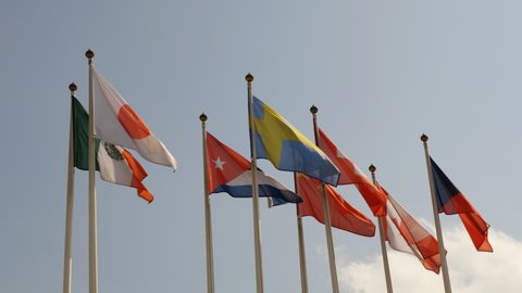 Various national flags with the EU flag under a blue sky.