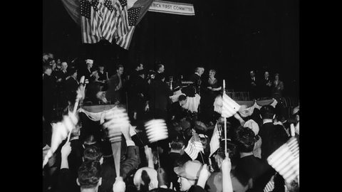 CIRCA 1941 - Attendees of an America First Committee convention wave American flags and cheer for Charles Lindbergh.