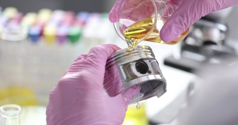 Scientist chemist pouring engine oil on piston of car closeup 4k movie slow motion