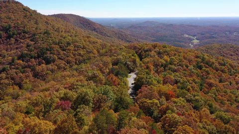BLUE RIDGE MOUNTAINS, GEORGIA - CIRCA 2020s - Aerial of mountain road and trees turning color in the Chattahoochee Oconee National Forest.