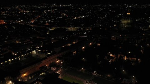 Aerial drone night video of Saint Peter's square, world's largest church - Papal Basilica of St. Peter's, Vatican - an elliptical esplanade created in the mid seventeenth century, Rome, Italy
