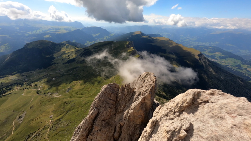 First person view over rocks. Drone view over mountains in Dolomites, Italy. Picturesque Sky over the Odle Group Mountains. Val Gardena.