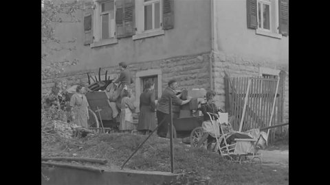 CIRCA 1945 - German civilians move their belongings out of their home in Merchigen, which is to be used as US Army headquarters.