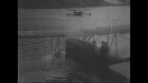 CIRCA 1925 - Seaplanes skim across the water off the coast of Greenland.
