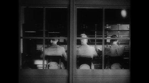CIRCA 1936 - Men operate a switchboard at the FBI to field calls about kidnappings, and other agents man teletype machines for communications.