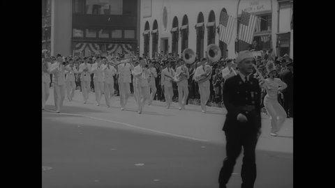 CIRCA 1937 - A US Navy band plays in an American Legion parade in New York City, followed by servicemen and women bearing flags.