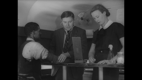 CIRCA 1939 - A white doctor checks a black man's blood pressure.