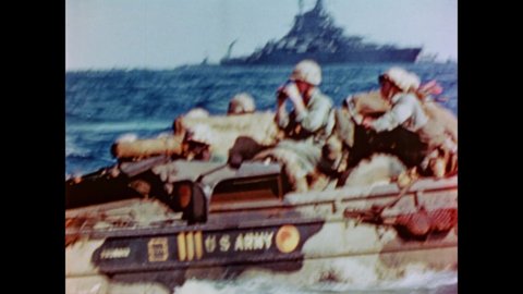 CIRCA 1945 - US Marines in landing crafts look at Iwo Jima through binoculars, and US Navy vessels provide cover.