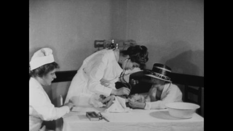 CIRCA 1919 - A man brings his baby to a clinic run by female doctors.