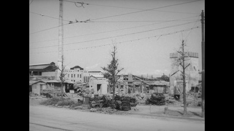 CIRCA 1945 - Streetcars drive by as a Japanese family begins salvage work in their war-torn neighborhood.