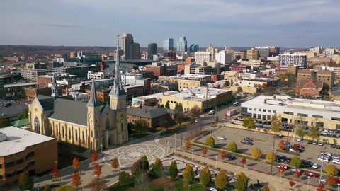 GRAND RAPIDS, MICHIGAN - CIRCA 2020s - Aerial past a cross on a church with the skyline of Grand Rapids, Michigan.