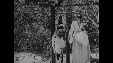 CIRCA 1919 - In this silent film, Anne Sullivan teaches young Helen Keller sign language at the water pump.