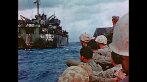 CIRCA 1945 - Landing crafts bearing US Marines come up alongside a US Navy troop transport ship.