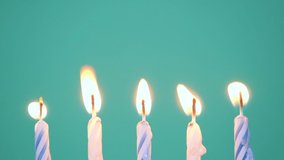 Happy Birthday concept Made of Burning Colorful Candles on blue or turquoise background. Blowing out five years anniversary birthday candles. Slow motion full HD video.