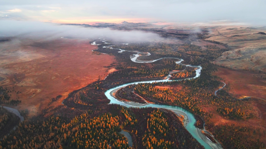 Chuya river in Kurai steppe, Altai mountains, Siberia, Russia. Aerial drone view. Blue river with yellow autumn trees with morning fog. Beautiful autumn nature landscape.
 Royalty-Free Stock Footage #1083674392