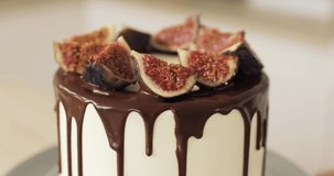 Caramel cake or cheesecake garnished with chocolate and figs. Rotating. Close-up. The concept of cooking cakes and desserts. Home confectionery.
