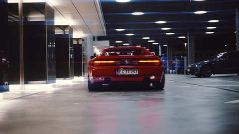 AARHUS, DENMARK - OCTOBER 2021: Wide Dolly Shot Moving Towards Rear Of Red Ferrari 348 TB From1991 With Rear Lights On Parked In Garage