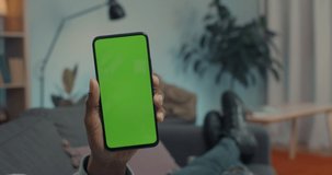 African american man with cold having video call with doctor on smartphone with chroma key screen. Close up of male hands holding nasal spray and modern cell phone.