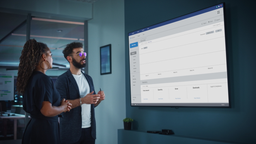 Company Marketing Director Holds Meeting Presentation for the CEO. Creative Male Uses TV Screen with Growth Analysis, Charts, Ad Revenue and Data. People Work in Business Office. | Shutterstock HD Video #1083680617