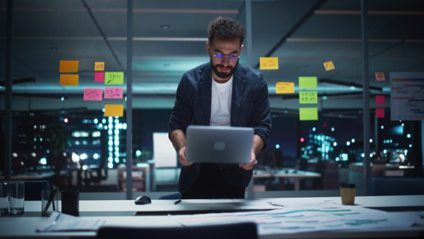 Successful Handsome Art Director Working on Laptop Computer in Big City Office Late in the Evening. Businessman Preparing for a Marketing Plan Meeting Discussion with Board Members in Conference Room. | Shutterstock HD Video #1083680656