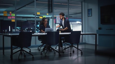 Businesspeople in Modern Office: Business Meeting of Two Managers. Female CEO and Operations Director Talk, Discuss Corporate Strategy, Implementing Marketing and Financial Plans. Evening Time.