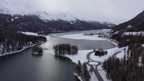 Aerial drone footage of the Champfer and Silvaplana lake in the Engadine valley in winter in the alps in Canton Graubunden in Switzerland. Shot with a rotation motion
